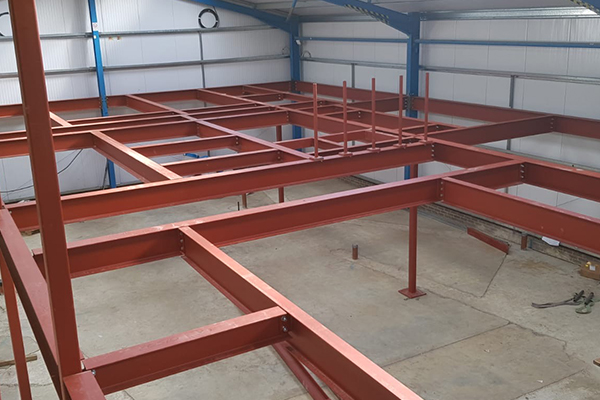 An image showing some metal I beams we fabricated now being used to create a building